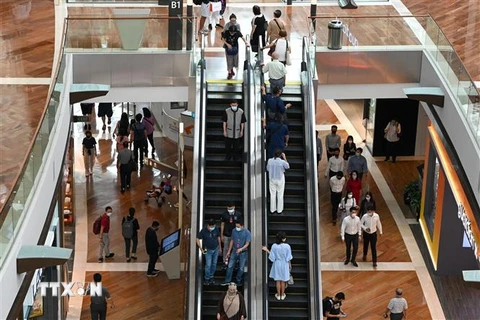 Người dân mua sắm tại trung tâm thương mại ở Singapore. (Ảnh: AFP/ TTXVN)
