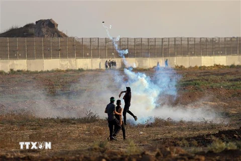 Người biểu tình Palestine ném trả đạn hơi cay về phía binh sĩ Israel trong cuộc đụng độ tại khu vực biên giới Dải Gaza-Israel, ngày 1/9/2023. (Ảnh: THX/TTXVN)