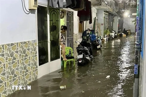 Nhiều hộ dân tại một tuyến hẻm trên đường Phan Huy Ích (quận Tân Bình) phải rào chắn, chốt chặt cửa để ngăn nước tràn vào nhà. (Ảnh: Hồng Giang/TTXVN)