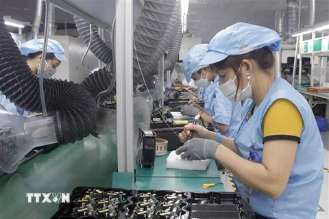 Công nhân Công ty TNHH Telstar Việt Nam, Khu Công nghiệp Vân Trung, Bắc Giang (vốn đầu tư của Anh) trong dây truyền sản xuất thiết bị điện tử. (Ảnh: Đồng Thúy/TTXVN)
