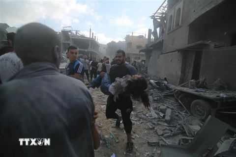 Chuyển một em nhỏ bị thương sau loạt không kích của Israel xuống thành phố Rafah, Dải Gaza ngày 17/10. (Ảnh: THX/TTXVN)