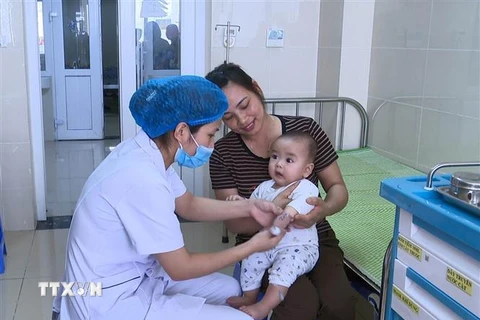 Nhân viên y tế Bệnh viện Sản Nhi Vĩnh Phúc thăm khám cho bệnh nhân nhi. (Ảnh: Nguyễn Thảo/TTXVN)