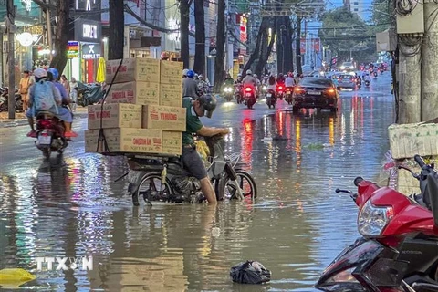 Người dân gặp khó khăn khi di chuyển do nước ngập trên đường Nguyễn Trãi, quận Ninh Kiều, chiều 28/10. (Ảnh: Thanh Liêm/TTXVN)