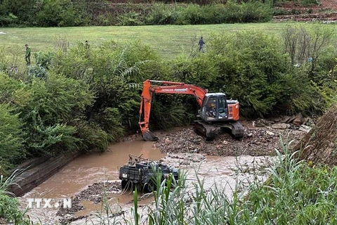 Hiện trường chiếc xe Jeep bị lũ cuốn trôi trên con suối ở Làng Cù Lần. (Ảnh: TTXVN phát)