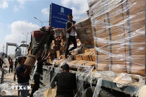 Bốc dỡ hàng viện trợ cho người dân Gaza tại khu vực cửa khẩu Rafah ngày 2/11/2023. (Ảnh: THX/TTXVN)