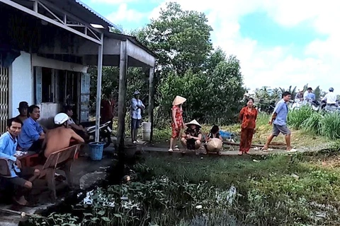 Người dân cùng chính quyền xã Tân Trung đến nhà Trần Minh Đắc giải cứu cháu bé 3 tuổi bị bạo hành. (Nguồn: Báo Thanh Niên)