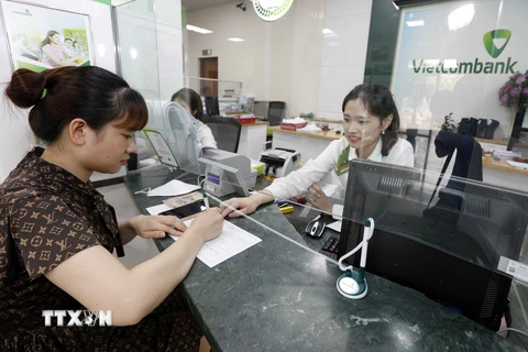 Khách hàng giao dịch tại Vietcombank Hà Nội. (Ảnh: Trần Việt/TTXVN)