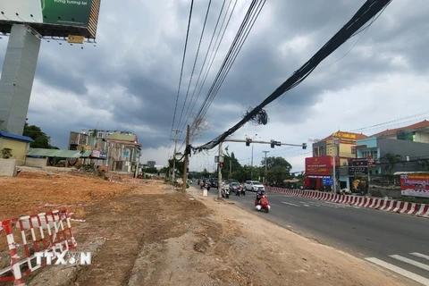 Hệ thống mạng lưới điện cũ nằm trong diện di dời để mở rộng Quốc lộ 13 đoạn qua tỉnh Bình Dương bị vướng kinh phí di dời, làm chậm tiến độ triển khai xây dựng. (Ảnh: TTXVN phát)