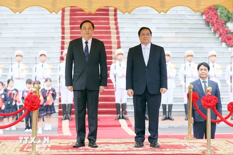 Thủ tướng Phạm Minh Chính và Thủ tướng Lào Sonexay Siphandone trên bục danh dự, nghe Quân nhạc cử Quốc thiều hai nước. (Ảnh: Dương Giang/TTXVN)
