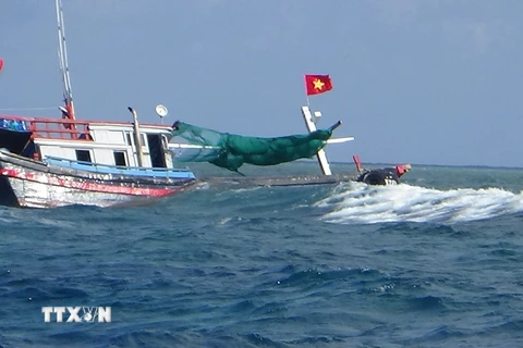 Tàu NT 02038TS bị mắc cạn và sóng đánh chìm. (Ảnh: TTXVN phát)