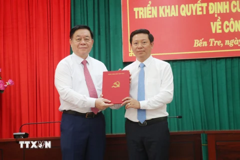 Trưởng Ban Tuyên giáo Trung ương Nguyễn Trọng Nghĩa (trái) trao Quyết định cho đồng chí Trần Thanh Lâm. (Ảnh: Chương Đài/TTXVN)