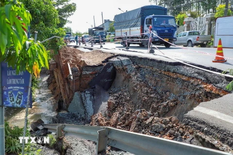 Tình trạng sạt lở bờ sông ảnh hưởng đến mặt đường nhựa Quốc lộ 80. (Ảnh: TTXVN phát)