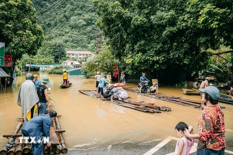 Tuyến đường thuộc thị trấn Pác Mjầu, huyện Bảo Lâm bị ngập sâu, người dân phải dùng bè mảng để di chuyển. (Ảnh: Bảo Chung/TTXVN phát)