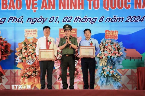 Bộ trưởng Bộ Công an Lương Tam Quang tặng Bằng khen của Bộ Công an cho đại diện tập thể nhân dân xã Phong Phú và cá nhân tiêu biểu huyện Tân Lạc. (Ảnh: Trọng Đạt/TTXVN)