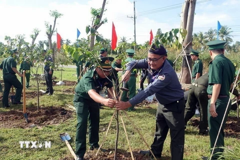 Đoàn đại biểu sỹ quan biên phòng Việt Nam - Campuchia trồng cây hữu nghị tại Đồn Biên phòng Lình Huỳnh, huyện Hòn Đất, tỉnh Kiên Giang. (Ảnh: Lê Sen/TTXVN)