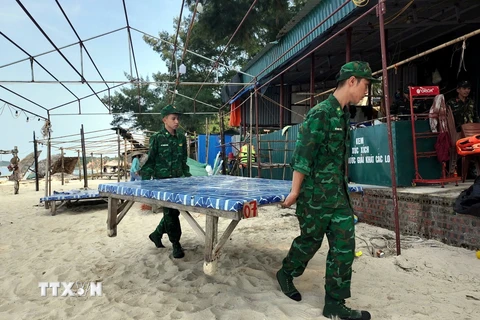 Lực lượng Biên phòng Cô Tô giúp người dân di chuyển đồ đạc về nơi an toàn. (Ảnh: TTXVN phát)