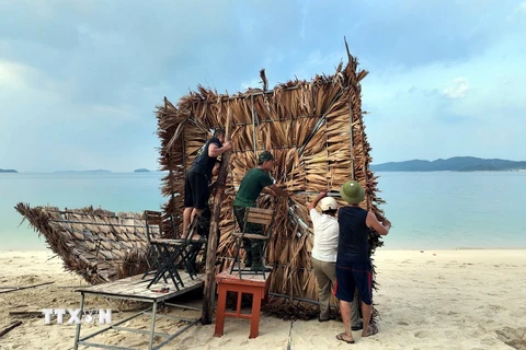 Lực lượng Biên phòng Cô Tô giúp người dân chằng chống cơ sở kinh doanh tại bãi biển Hồng Vàn. (Ảnh: TTXVN phát)