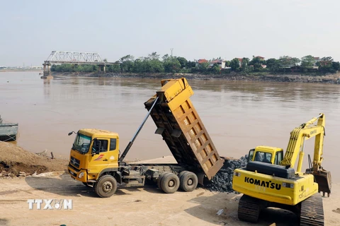 Lực lượng quân đội đang hoàn tất công đoạn cuối cùng ở 2 phía đầu đường dẫn trước khi lắp đặt cầu phao. (Ảnh: Tạ Toàn/TTXVN)