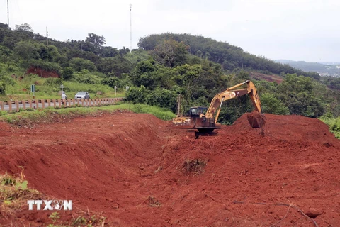 Máy múc san gạt, di chuyển các khối đất để bảo vệ hành lang đường Hồ Chí Minh. (Ảnh: Hưng Thịnh/TTXVN)