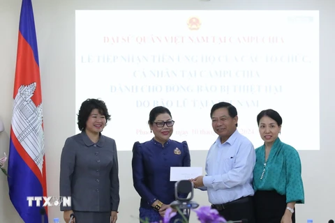 Bà Chea Sam Eng, đại diện thế hệ sinh viên là con em lãnh đạo cấp cao Campuchia học tập tại Việt Nam giai đoạn 1980-1987, trao số tiền quyên góp ủng hộ. (Ảnh: Huỳnh Thảo/TTXVN)