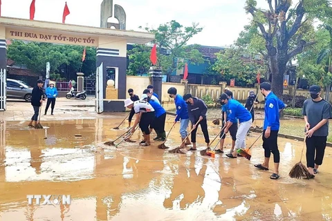 Các đội hình thanh niên tình nguyện xung kích, hỗ trợ các điểm trường trên địa bàn huyện Quảng Ninh, tỉnh Quảng Bình dọn vệ sinh sau mưa, lũ. (Ảnh: TTXVN phát)