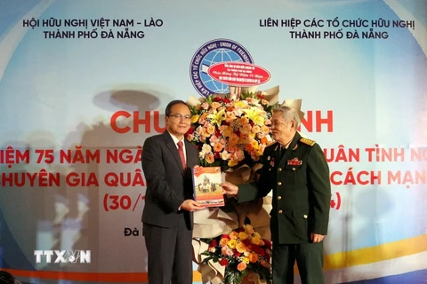 Ông Hồ Kỳ Minh, Phó Chủ tịch Thường trực Ủy ban Nhân dân thành phố Đà Nẵng, Chủ tịch Hội hữu nghị Việt Nam-Lào thành phố tặng hoa cho đại diện Ban liên lạc Quân tình nguyện và Chuyên gia quân sự Việt Nam giúp Cách mạng Lào. (Ảnh: TTXVN phát)