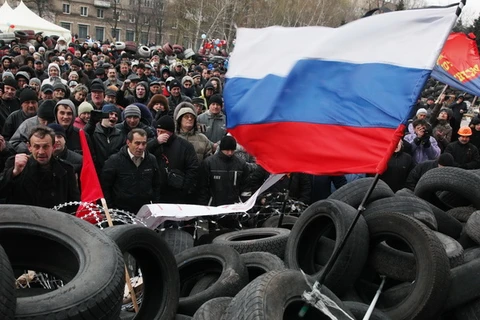 Người biểu tình bên rào chắn bên ngoài tòa nhà chính quyền thành phố Donetsk, miền đông Ukraine ngày 11/4. (Nguồn: AFP/TTXVN)