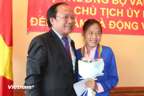 Bộ trưởng Hoàng Tuấn Anh trao lại huy chương vàng SEA Games 27 cho vận động viên đi bộ Nguyễn Thị Thanh Phúc. (Ảnh: Việt Hải-Lê Hải/Vietnam+)