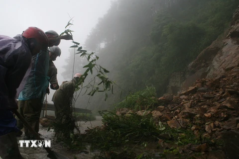 Công nhân Hạt Giao thông 4 thu dọn đất đá ở những điểm sạt lở trên tuyến đường lên Khu du lịch Mẫu Sơn. (Ảnh: Doãn Hoàng Nam/TTXVN)