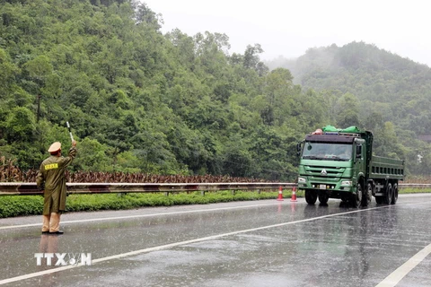 Cảnh sát Giao thông tỉnh Lạng Sơn phân luồng đảm bảo an toàn giao thông tại điểm sạt lở Km 25+200 trên Quốc lộ 1A. (Ảnh: Thái Thuần/TTXVN)