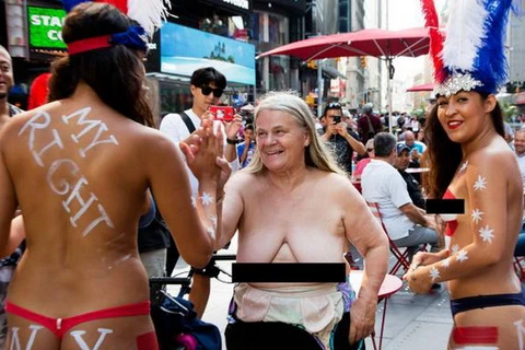 Bà Claire Hogenauer, 69 tuổi, cùng hai cô gái trẻ để ngực trần tại quảng trường Thời Đại. (Nguồn: nydailynews)