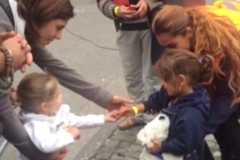 Bé gái người Đức chia kẹo cho một em bé tị nạn. (Nguồn: DM)