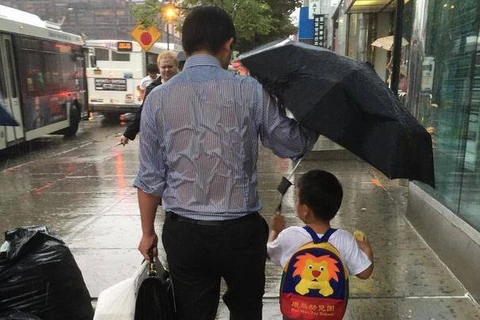 Bức ảnh người cha che ô cho con gây sốt cộng đồng mạng. (Nguồn: CCTV News)