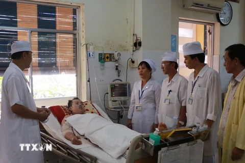 Bác sỹ Bệnh viện Đa khoa Sóc Trăng thăm hỏi bệnh nhân Trần Tuấn Quốc. (Ảnh: Chanh Đa​/TTXVN)