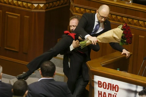 Nghị sỹ đối lập nhấc bổng thủ tướng Arseniy Yatsenyuk ra khỏi bục phát biểu. (Nguồn: Reuters)