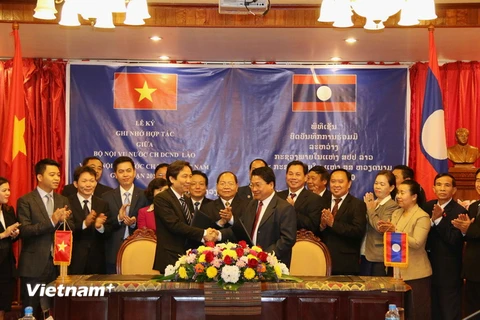 Thứ trưởng Trần Anh Tuấn bắt tay Thứ trưởng Bộ Nội vụ Lào Khammoune Viphongsay. (Ảnh: Phạm Kiên/Vietnam+)