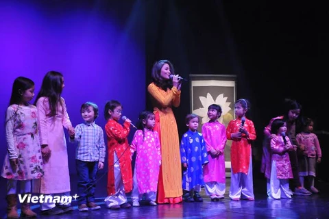 Ca sỹ Thu Trang biểu diễn cùng các em nhỏ trong trình 'Xuân quê hương' hôm 13/2 ở Brussels. (Ảnh: Hương Giang/Vietnam+)