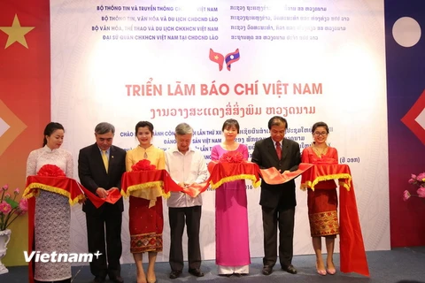 Cắt băng khai mạc triển lãm báo chí Việt Nam tại Lào. (Ảnh: Phạm Kiên/Vietnam+)