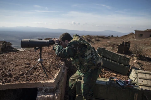 Một binh sỹ quân chính phủ Syria theo dõi đối phương trên chiến tuyến. (Ảnh: quan_doi_Syria.sputniknews)