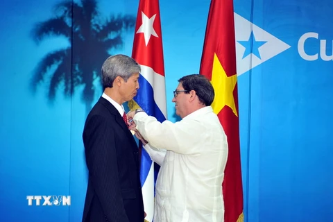 Bộ trưởng Ngoại giao Cuba trao tặng Huy chương Hữu nghị cho Đại sứ Dương Minh. (Ảnh: Lê Hà/TTXVN)