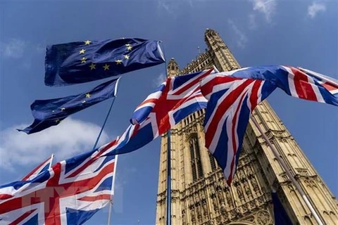 Cờ Anh (phía dưới) và cờ EU (phía trên) bên ngoài tòa nhà Quốc hội Anh ở London. (Ảnh: AFP/TTXVN)
