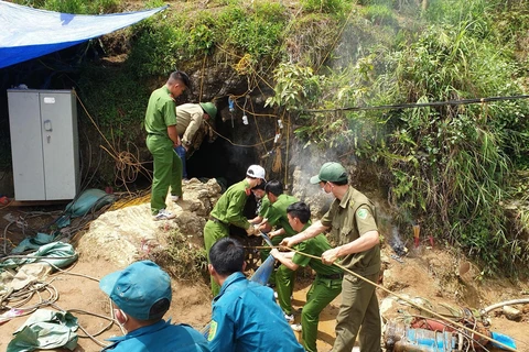 Lực lượng chức năng thực hiện các biện pháp cứu hộ cứu nạn để đưa người đàn ông bị mắc kẹt trong hang ra ngoài. (Ảnh: Quốc Khánh/TTXVN)