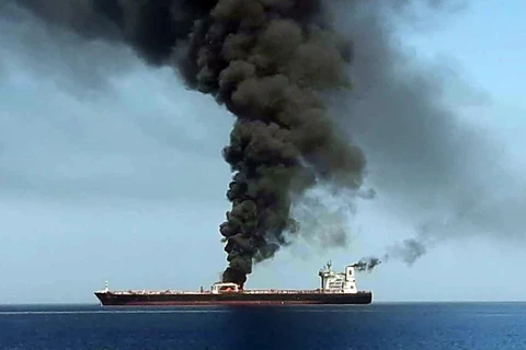 Khói bốc ngùn ngụt từ một tàu chở dầu sau sự cố được cho là một 'vụ tấn công từ bên ngoài' ở ngoài khơi bờ biển Oman ngày 13/6. (Ảnh: AFP/TTXVN)