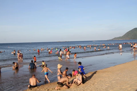 Bãi biển Thiên Cầm hút hút lượng lớn người lớn và trẻ em ra tắm tránh nắng nóng. (Ảnh: Phan Quân/TTXVN)