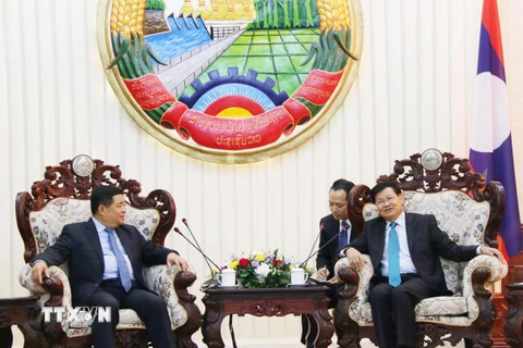 Thủ tướng Chính phủ Lào Thongloun Sisulith (phải) tiếp thân mật Bộ trưởng Nguyễn Chí Dũng. (Ảnh: Xuân Tú/TTXVN)