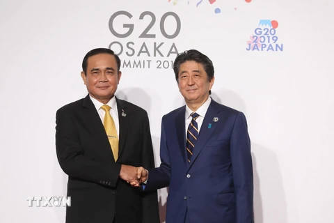 Thủ tướng Nhật Bản Shinzo Abe (phải) và Thủ tướng Thái Lan Prayut Chan-o-cha trong cuộc gặp tại Hội nghị thượng đỉnh G20 ở Osaka, Nhật Bản. (Ảnh: AFP/TTXVN)