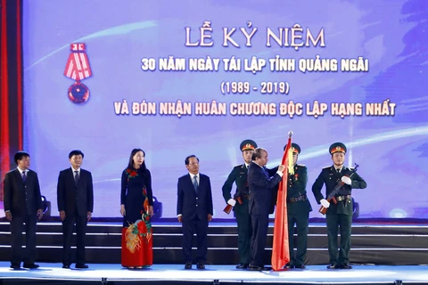 Thủ tướng Nguyễn Xuân Phúc gắn Huân chương Độc lập hạng Nhất lên cờ truyền thống của tỉnh Quảng Ngãi. (Ảnh: Thống Nhất/TTXVN)