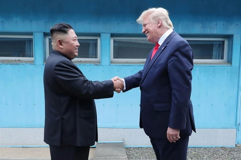 Tổng thống Mỹ Donald Trump (phải) và nhà lãnh đạo Triều Tiên Kim Jong-un (trái) bất ngờ gặp lại nhau tại DMZ. (Ảnh: AFP/TTXVN)