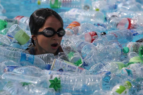 Một nữ sinh bơi giữa bể nước đầy chai nhựa để nâng cao nhận thức của mọi người về rác thải nhựa. (Nguồn: bangkokpost)