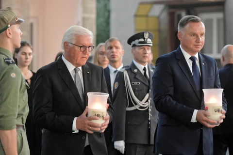 Tổng thống Đức Frank-Walter Steinmeier (trái) và Tổng thống Ba Lan Andrzej Duda (phải) thắp nến tưởng nhớ các nạn nhân. (Ảnh: PAP/TTXVN)